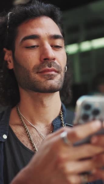 실용적 곱슬머리와 매력적 이탈리아 핸드폰을 사용하고 있습니다 남자가 스마트폰으로 메시지를 — 비디오