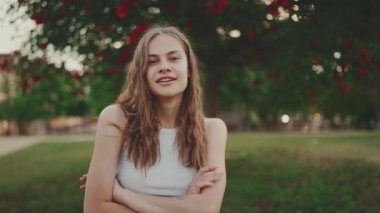 Koyu sarı dalgalı saçlı, gülümseyen güzel kız. Güzel kız kameraya gülümsüyor.