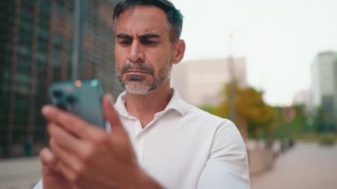 Düzgün sakallı olgun iş adamı cep telefonu kullanır. Başarılı bir adam akıllı telefondan mesaj göndererek bilgileri aktarır.