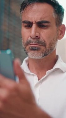 Düzgün sakallı olgun iş adamı cep telefonu kullanır. Başarılı bir adam akıllı telefondan mesaj göndererek bilgileri aktarır.
