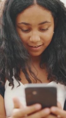 Ergenlik öncesi kız rıhtımda otururken cep telefonu kullanıyor. Genç kız akıllı telefondan video görüşmesi yapıyor.