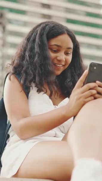 Vertisk Video Förtida Tonårstjej Använder Mobiltelefon När Hon Sitter Vid — Stockvideo