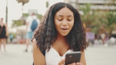 Genç kız rıhtımda otururken cep telefonu kullanıyor. Genç kız akıllı telefondan video görüşmesi yapıyor.