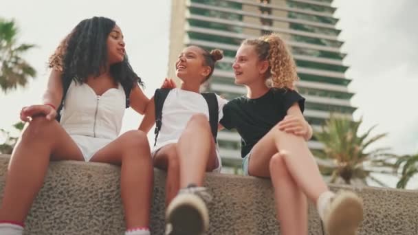 Drie Vriendinnen Van Voor Hun Tienerjaren Zitten Aan Het Water — Stockvideo