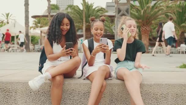 Drie Pre Tienervriendinnen Zitten Aan Het Water Met Een Mobiele — Stockvideo