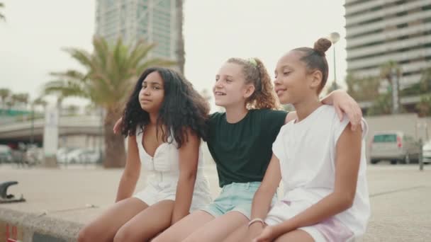 三个未成年少女坐在那里 看着游艇和轮船在海滨的景色 — 图库视频影像