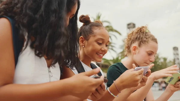 Trzy Nastoletnie Koleżanki Siedzą Nabrzeżu Używając Telefonu Komórkowego Troje Nastolatków — Zdjęcie stockowe