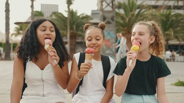 三个十几岁前的女孩朋友笑着坐在海滨试吃冰淇淋 三个孩子在炎炎夏日吃冰淇淋 — 图库照片