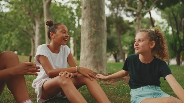 Trzy Nastoletnie Koleżanki Siedzą Trawie Parku Emocjonalnie Rozmawiają Trójka Nastolatków — Zdjęcie stockowe