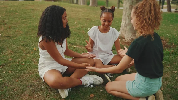 Śmiejąc Się Trzech Koleżanek Nastolatek Siedzi Trawie Parku Bawiąc Się — Zdjęcie stockowe