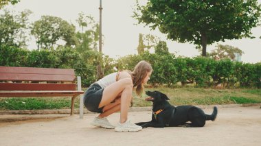 Kız arka köpekle parkta yürüyor..