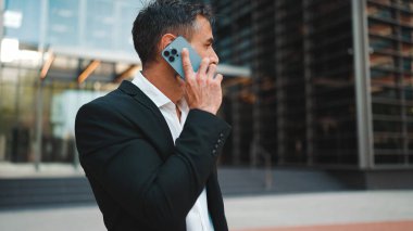 Ofis kıyafetleri içinde sakallı orta yaşlı bir işadamı cep telefonu kullanıyor. Başarılı bir adam duygusal olarak akıllı telefondan konuşuyor. Hayal kırıklığı, sorun.