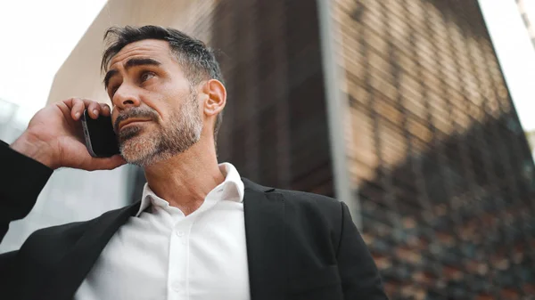 Ofis kıyafetleri içinde sakallı orta yaşlı bir işadamı cep telefonu kullanıyor. Başarılı bir adam duygusal olarak akıllı telefondan konuşuyor. Hayal kırıklığı, sorun.
