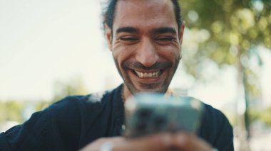 At kuyruklu ve sakallı çekici İtalyan adam eski binaların arkasındaki bankta oturan cep telefonunu kullanıyor. Tarz sahibi bir adam mesaj yazar, akıllı telefondan fotoğrafa bakar