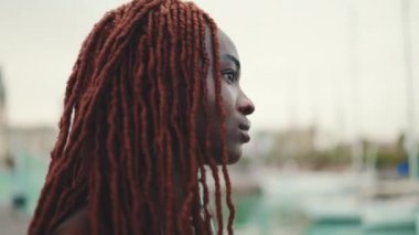 Deniz manzaralı Afrika örgülü muhteşem kadın profiline yakın plan.