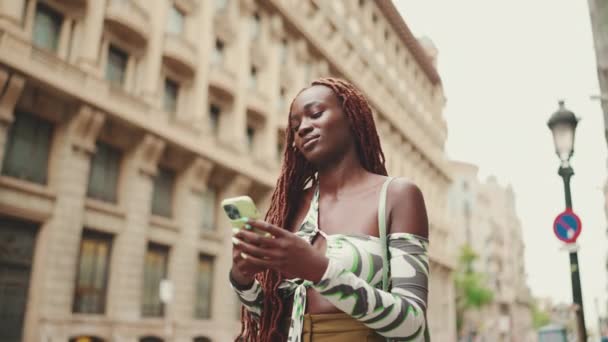 Mosolygó Gyönyörű Afrikai Copfos Felső Áll Járdán Mellett Használja Mobiltelefon — Stock videók