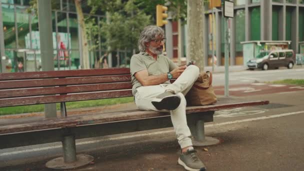 Pozytywny Mężczyzna Średnim Wieku Siwymi Włosami Brodą Luźnych Ubraniach Siedzi — Wideo stockowe