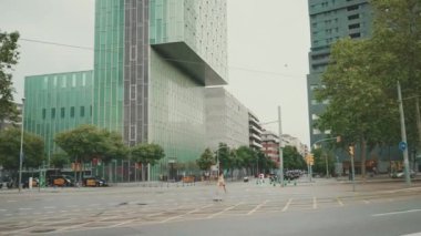 Barselona 'da. Şehir manzarası kavşağı. Modern bina geçmişleri. Yoldan geçen arabalar