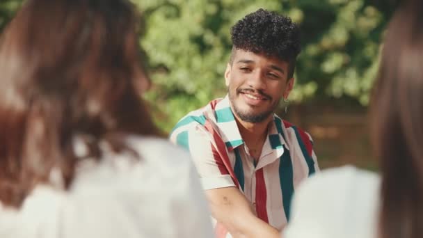 Close Young Man Curly Hair Wearing Striped Shirt Sitting Park — Stockvideo
