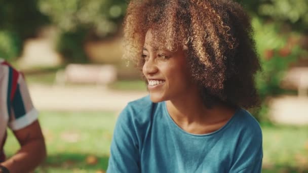 Крупный План Молодой Женщины Кудрявыми Волосами Голубой Футболке Сидящей Парке — стоковое видео