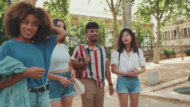 Счастливая Многонациональная Молодежь Идет Улице Разговаривая Летний День Группа Друзей — стоковое видео