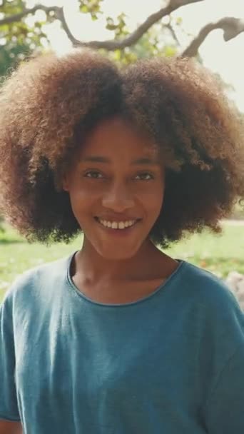 Видео Крупный План Молодой Улыбающейся Женщины Вьющимися Волосами Голубой Футболке — стоковое видео