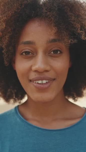 Vertical Video Close Young Smiling Woman Curly Hair Wearing Blue — Stock Video