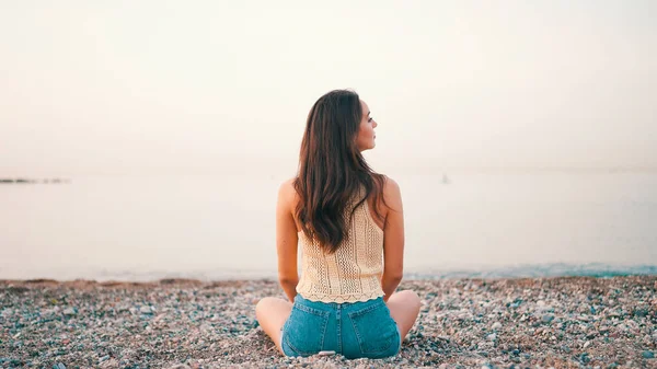 Beautiful Brown Haired Woman Long Hair Sits Beach Seascape Background — Fotografia de Stock
