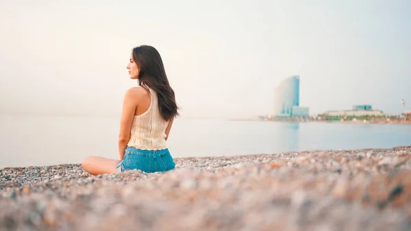 Beautiful Brown Haired Woman Long Hair Sits Beach Seascape Background — Fotografia de Stock
