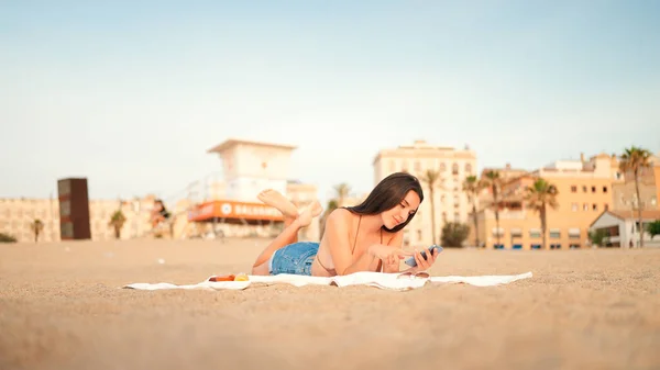 Karcsú Gyönyörű Barna Hajú Hosszú Hajjal Mobiltelefont Használ Miközben Strandon — Stock Fotó