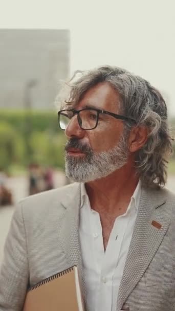 Vertical Video Mature Businessman Beard Eyeglasses Wearing Gray Jacket Holding — Vídeo de stock