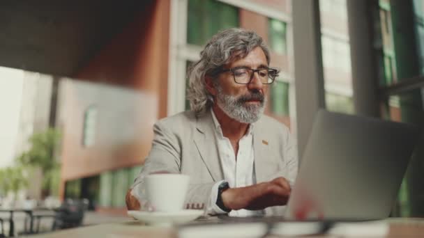 Mature Businessman Beard Eyeglasses Wearing Gray Jacket Sits Drinks Coffee — Vídeo de stock