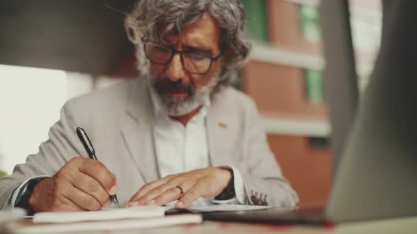 Mature Businessman Beard Eyeglasses User Laptop Computer Taking Notes Sitting — стоковое видео