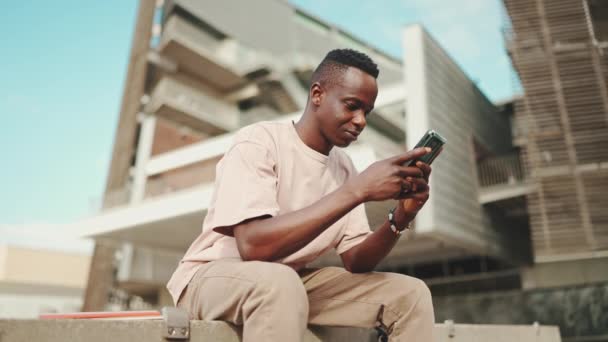 Young African Student Sits University Uses Cellphone — Vídeo de stock