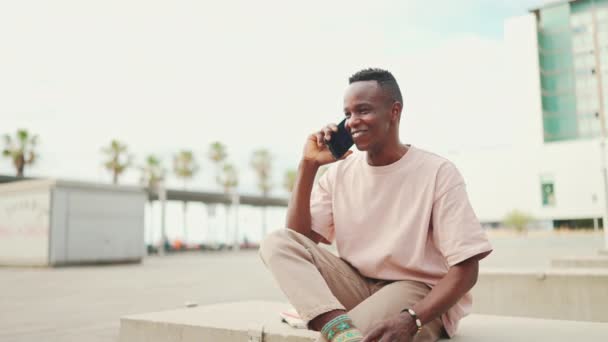 Smiling Young African Student Sitting University Talking Cellphone Blurred Background — Vídeos de Stock