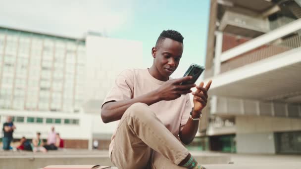 Usmívající Mladý Africký Student Sedí Mimo Univerzitu Mluví Mobilu — Stock video