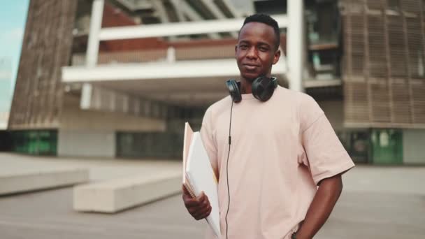 Young African Student Stands University Wearing Headphones Smiling Looking Camera — Stockvideo