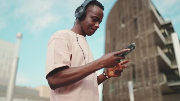 Young African Student Goes University Headphones Uses Phone Listens Music — Stockvideo