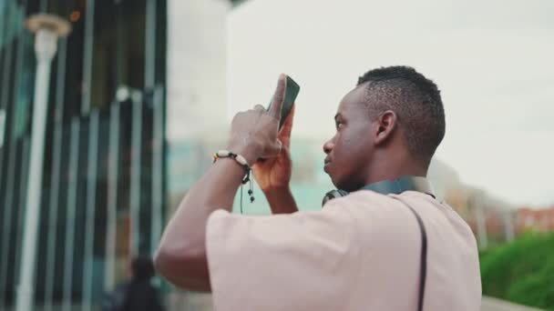 Young African Student Uses Cellphone Takes Photo Camera Moves Sideway — Stock Video