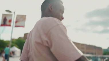 Genç Afrikalı adam deniz kenarındaki yat ve gemilere bakıyor.