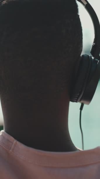 Vertical Video Clouse Mladý Afričan Relaxuje Lavičce Přístavu Poslouchá Hudbu — Stock video