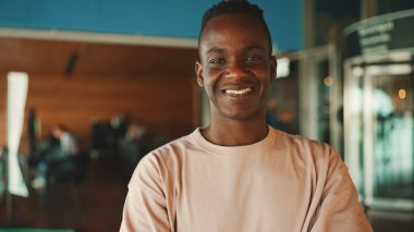 Kameraya bakan mutlu, genç Afrikalı adamın yakın çekimi.