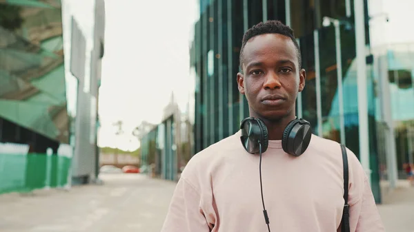 Young African Student Stands University Wearing Headphones Smiling Looking Camera — Φωτογραφία Αρχείου