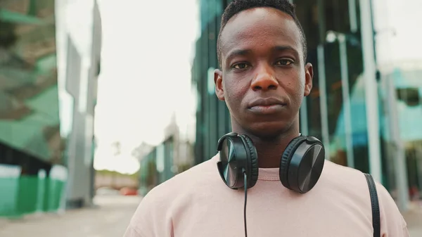 Young African Student Stands University Wearing Headphones Smiling Looking Camera — Φωτογραφία Αρχείου