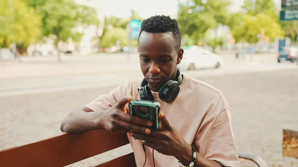 Smiling Young African Student Sits Bench University Headphones Uses Phone — Stock Fotó