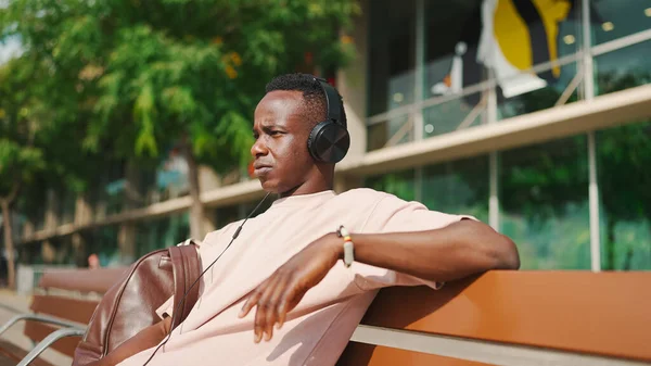 Smiling Young African Guy Relaxes Sitting Bench Port Listens Music — Φωτογραφία Αρχείου