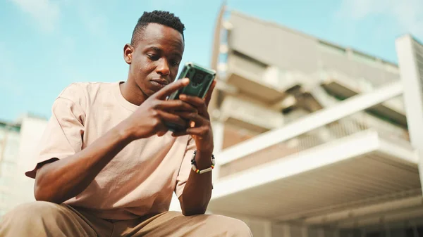 Young African Student Sits University Uses Cellphone Taps Smartphone Screen — Stockfoto