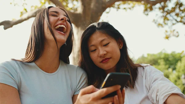 Młode Wieloetniczne Uśmiechnięte Kobiety Oglądają Filmy Telefonie Dziewczyny Śmieją Się — Zdjęcie stockowe