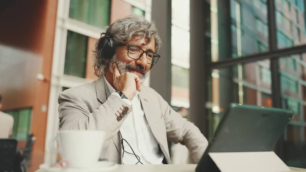 Mature Businessman Beard Eyeglasses Headphones Sits Outdoor Cafe Works Using — Foto de Stock