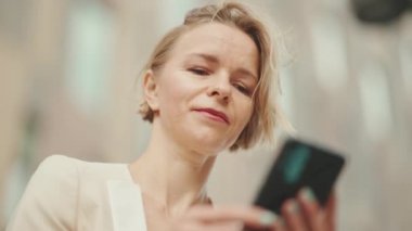 Close up, businesswoman with blond hair using cellphone